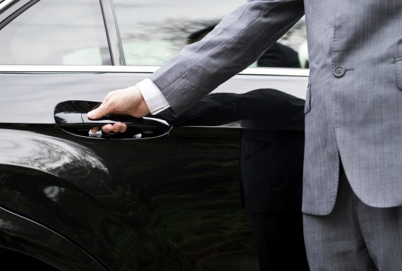 Closeup of a doormans opening a car door.